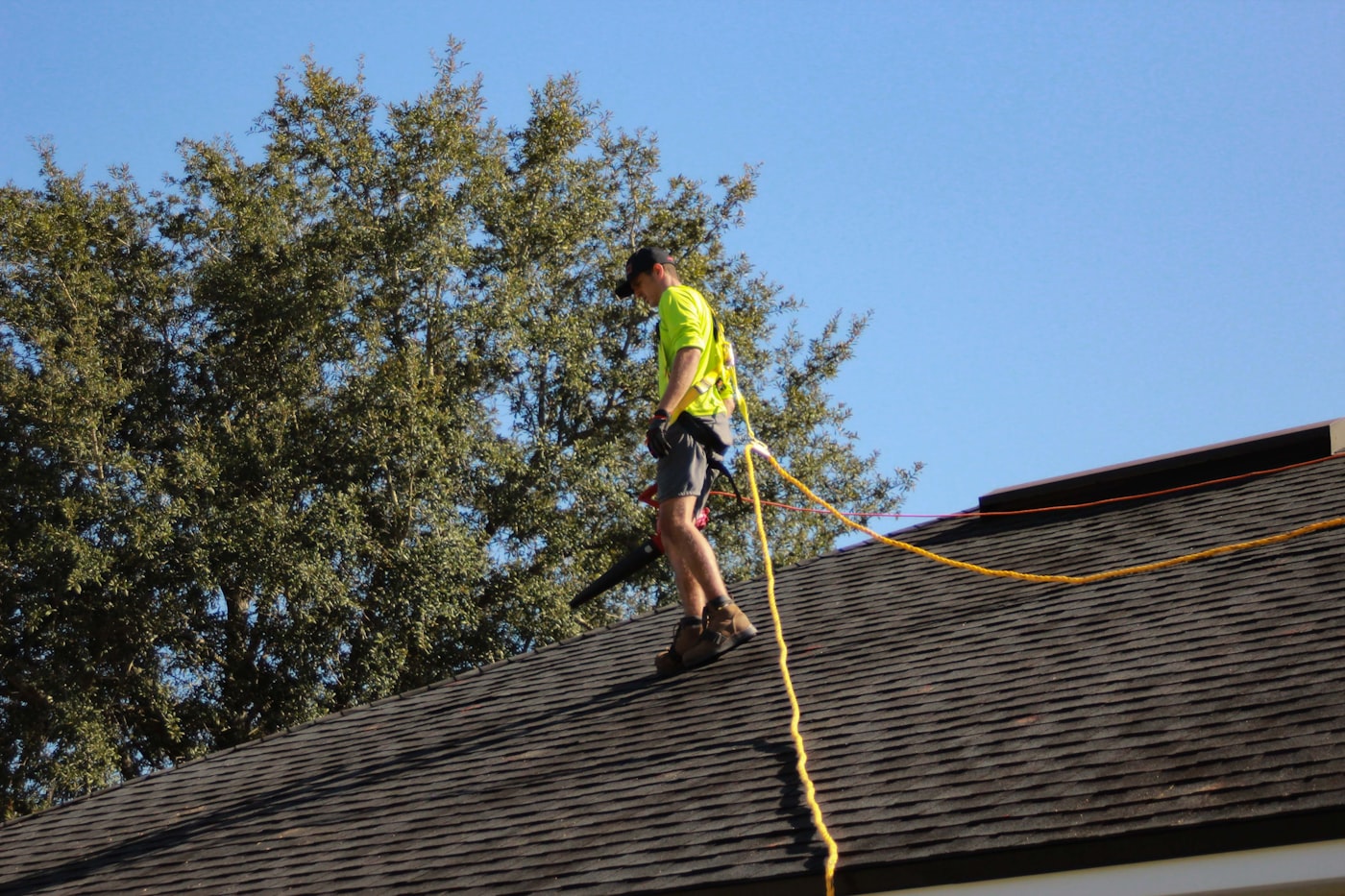 Roofer inspecting and repairing residential shingles
